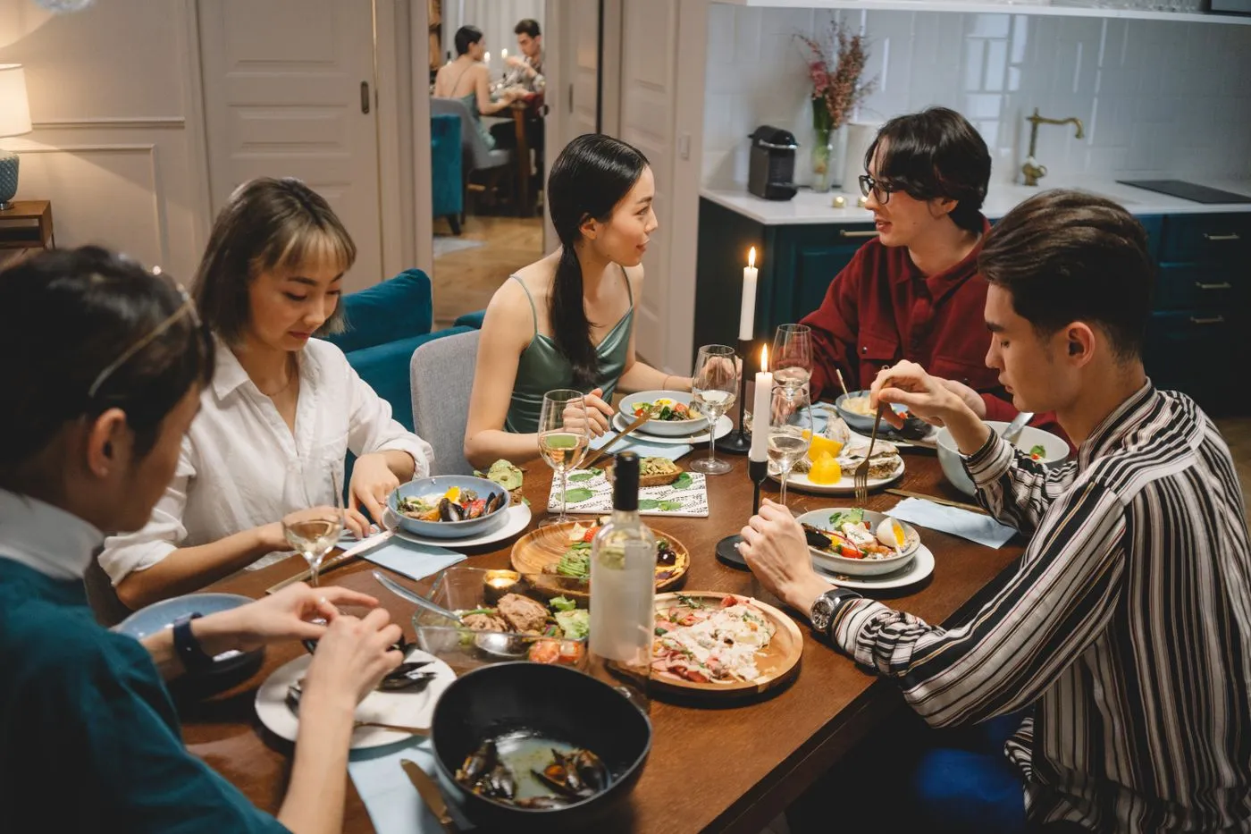 Un grupo de personas comparte una cena con velas y conversación.